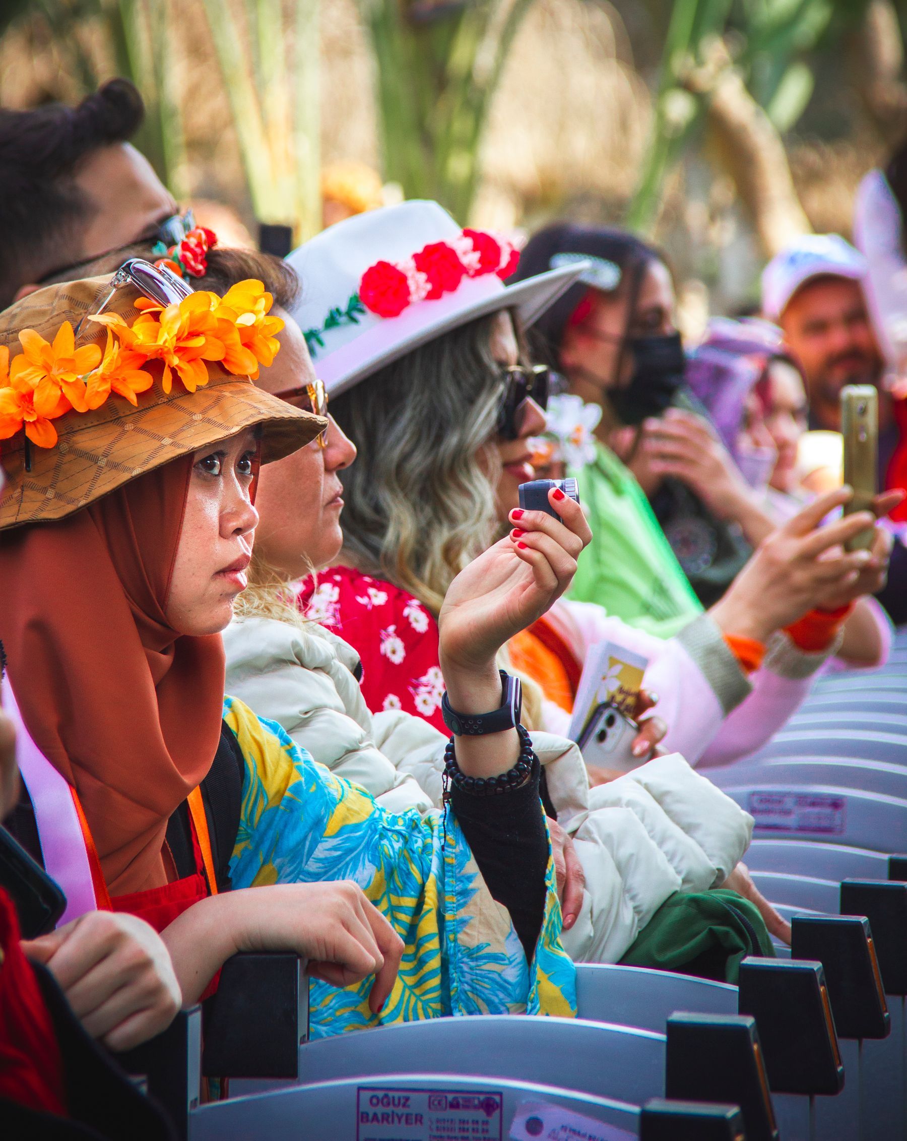A crowd in bright floral hats at a festival